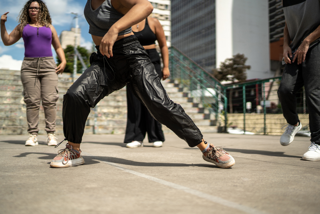 Low section of friends dancing outdoors